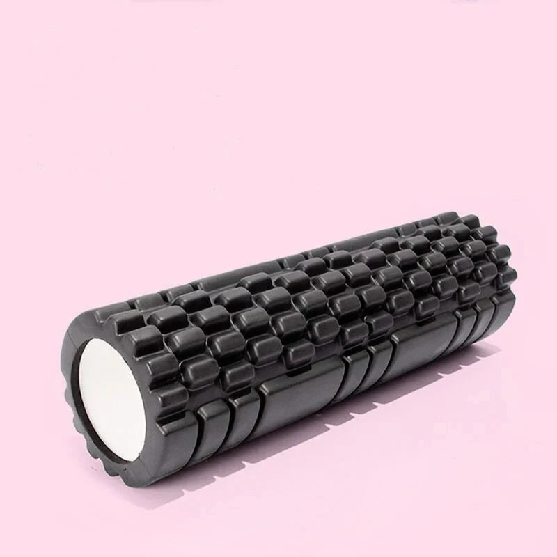 Black textured fitness roller on a pink studio background